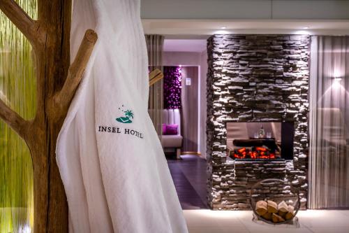 a living room with a fireplace and a curtain at Insel Hotel Bonn - Superior in Bonn