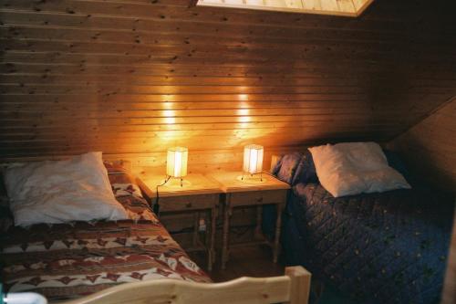 dos camas en una cabina con dos lámparas. en chalet jennifer, en Laveissière