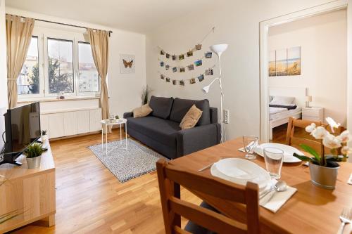uma sala de estar com uma mesa e um sofá em Gemütliche Wohnung in zentraler Lage em Graz