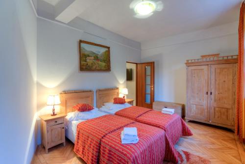 a bedroom with a bed and two tables and two lamps at House of Dragons Apartments in Sighişoara