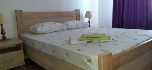 a bed with two pillows and a tray on it at Splendid Aparthotel in Năvodari
