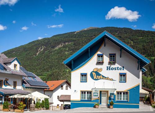 un hotel con una montaña al fondo en Rutsche Hostel, en Wenns