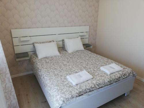 a small bed with two white pillows on it at Willa Mazury in Iława