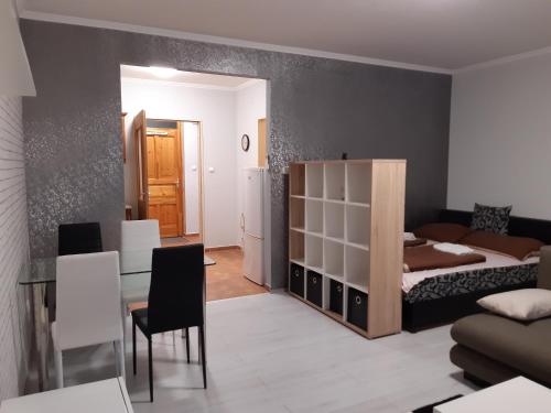 een woonkamer met een bed en een tafel en stoelen bij Pipacs in Békéscsaba