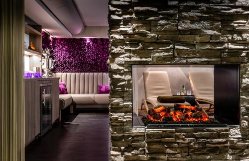 a fireplace in a living room with a stone wall at Insel Hotel Bonn - Superior in Bonn