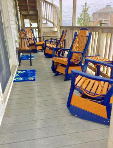 a row of blue chairs sitting on a porch at Moody's Motel and Cottages in Wells