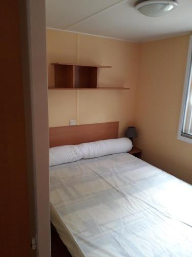 une chambre avec un grand lit blanc dans une pièce dans l'établissement mobil home, à Médis