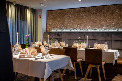 a dining room with white tables and chairs with candles at Insel Hotel Bonn - Superior in Bonn