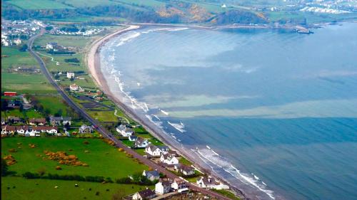 an aerial view of a beach with houses and the ocean at Cullentra House in Cushendall