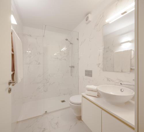 a white bathroom with a toilet and a sink at Uma Formosa Apartments in Porto