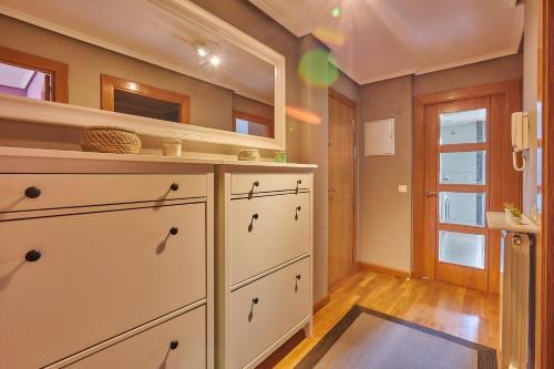 a kitchen with a white dresser and a shelf at Lujoso bajo con jardín y garaje in Cirueña