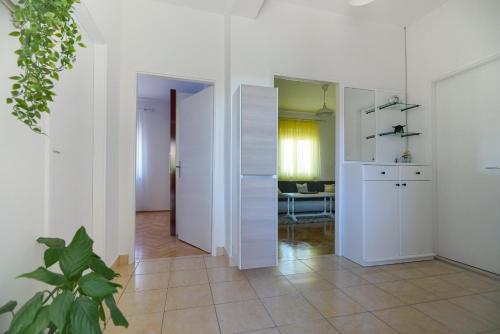 a room with white walls and a kitchen with a table at Apartment Jardin with free cowered parking in Zadar