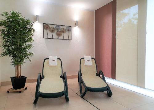 two chairs in a waiting room with a plant at Autenrieder Brauereigasthof in Ichenhausen