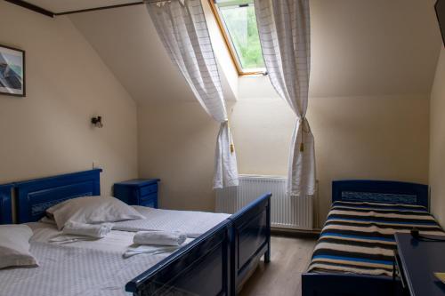 a bedroom with two beds and a window at Pensiunea Sanziana in Gura Rîului