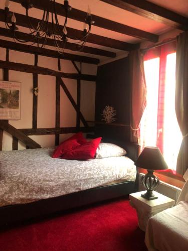 a bedroom with a bed with red pillows on it at Tim's secret place in Honfleur