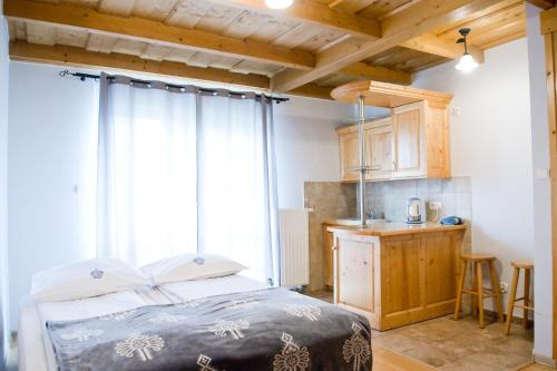 a bedroom with a bed and a kitchen with a window at Willa u Bohuna in Zakopane