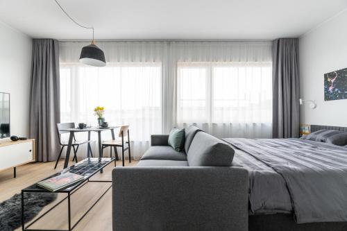 a bedroom with a bed and a table and a dining room at Ülemiste City Residences in Tallinn