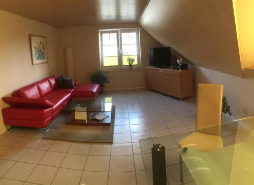 sala de estar con sofá rojo y TV en Ländlich ruhig 10 km vor Rostock, en Dummerstorf
