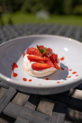 a dessert with strawberries on a plate on a table at Innishannon House Hotel in Inishannon