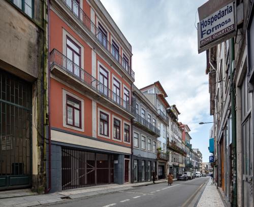 a city street with buildings and a person walking down the street at Uma Formosa Apartments in Porto