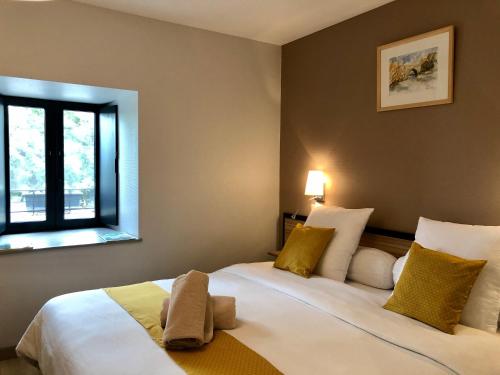 1 dormitorio con 2 camas y ventana en Auberge du Cezallier en Montgreleix
