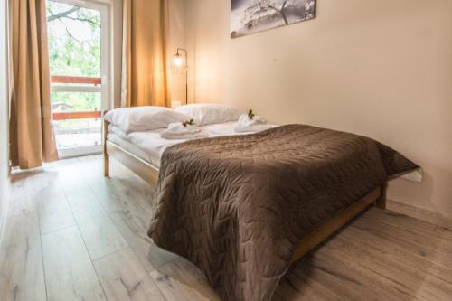 a bedroom with a bed with two towels on it at Apartamenty Izerskie - ul. Sienkiewicza 9 in Świeradów-Zdrój