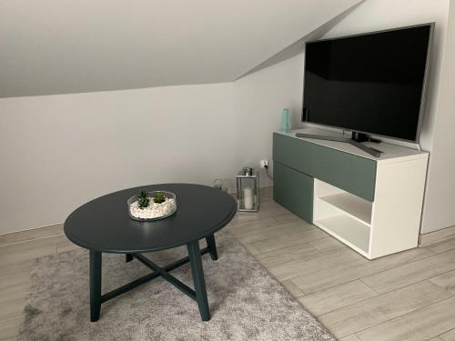 a living room with a table and a flat screen tv at Czarna Góra Haven in Sienna