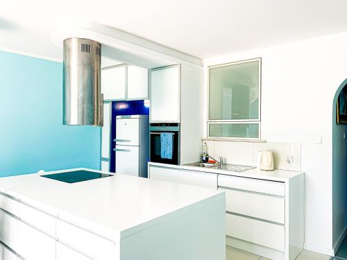 ソポトにあるSopockie Santoriniの青い壁のキッチン(白いキャビネット付)