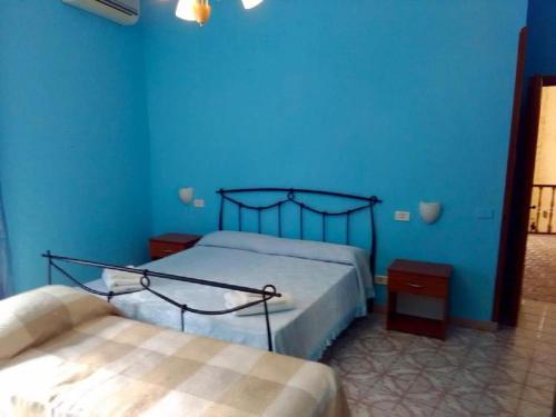 a blue bedroom with two beds and a blue wall at Villa Lembo in Agnone