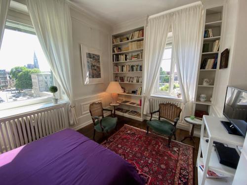 史特拉斯堡的住宿－Les Lumières de la ville，一间卧室配有一张床、一张桌子和两把椅子