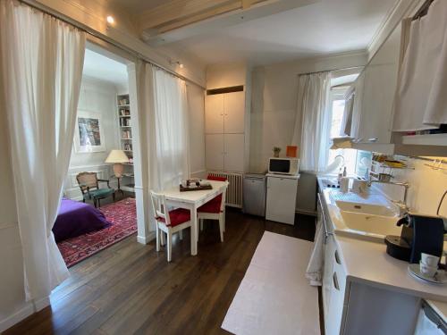 a kitchen and living room with a table in a room at Les Lumières de la ville in Strasbourg