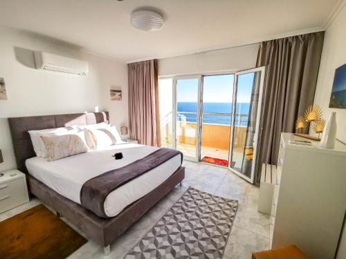 a bedroom with a bed with a view of the ocean at Apartment Jardins Gold Vista Mar in Portimão