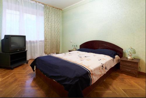 a bedroom with a large bed and a television at Двушка Печерск in Kyiv