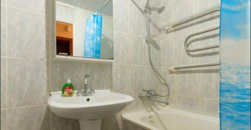a white bathroom with a sink and a shower at Двушка Печерск in Kyiv
