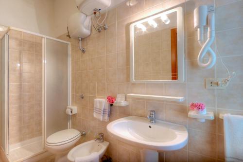 a bathroom with a sink and a toilet and a mirror at Centro Vacanze Verde Azzurro in Cingoli