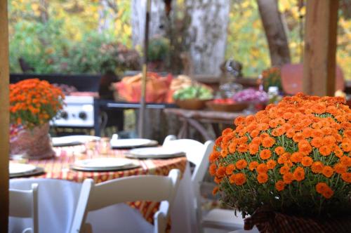 a table with white chairs and orange flowers at Creekwalk Inn Bed and Breakfast with Cabins in Cosby