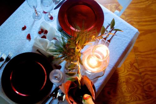 a table with red plates and a candle on it at Creekwalk Inn Bed and Breakfast with Cabins in Cosby