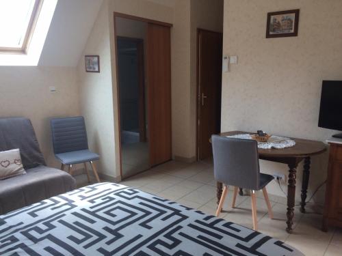 une chambre avec un lit, une table et des chaises dans l'établissement Mélodies d'Alsace, à Lipsheim