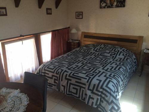 a bedroom with a bed with a black and white comforter at Mélodies d'Alsace in Lipsheim