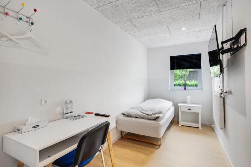 Dieses weiße Zimmer verfügt über einen Schreibtisch und ein Bett. in der Unterkunft Gørding Bed and Breakfast in Gørding
