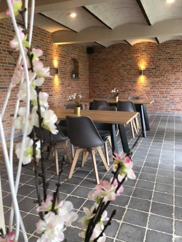 a restaurant with tables and chairs and a brick wall at B&B DeSo in Zonnebeke