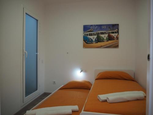 sypialnia z 2 łóżkami i obrazem na ścianie w obiekcie CUPIDO Apartamento moderno en el centro de Blanes w Blanes