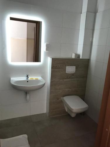 a bathroom with a sink and a toilet and a mirror at Motel Pintal in Gorzów Wielkopolski