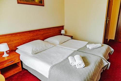 two beds in a hotel room with towels on them at Panorama_SPA in Trzęsacz