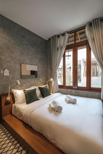 a bedroom with a large bed with towels on it at Hidden Garden Hostel in Chiang Mai