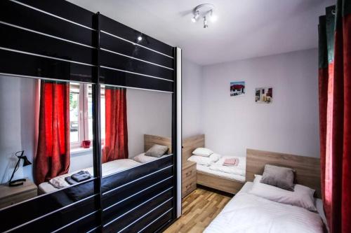 1 dormitorio con 2 camas y cortinas rojas en Apartament u Miecia en Mielno