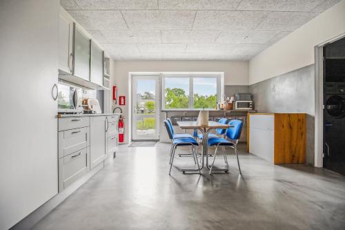 a kitchen with a table and blue chairs at Gørding Bed and Breakfast in Gørding