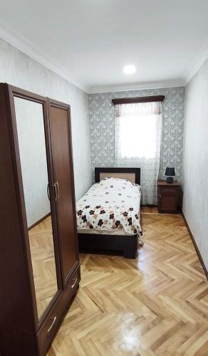 a bedroom with a bed and a wooden floor at EleGaya Guest house in Ijevan