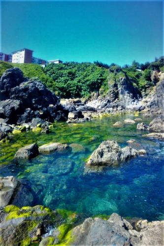 a body of water with rocks and blue water at KosmeEtxea, la casa del Parque EBI727 in Bermeo
