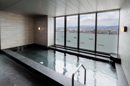 a swimming pool with a view of the water at JR Inn Hakodate in Hakodate